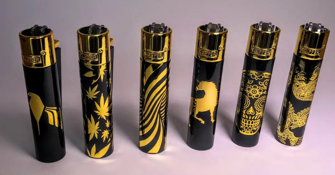 Set of six black and gold Clipper lighters featuring various intricate designs, including patterns and animals