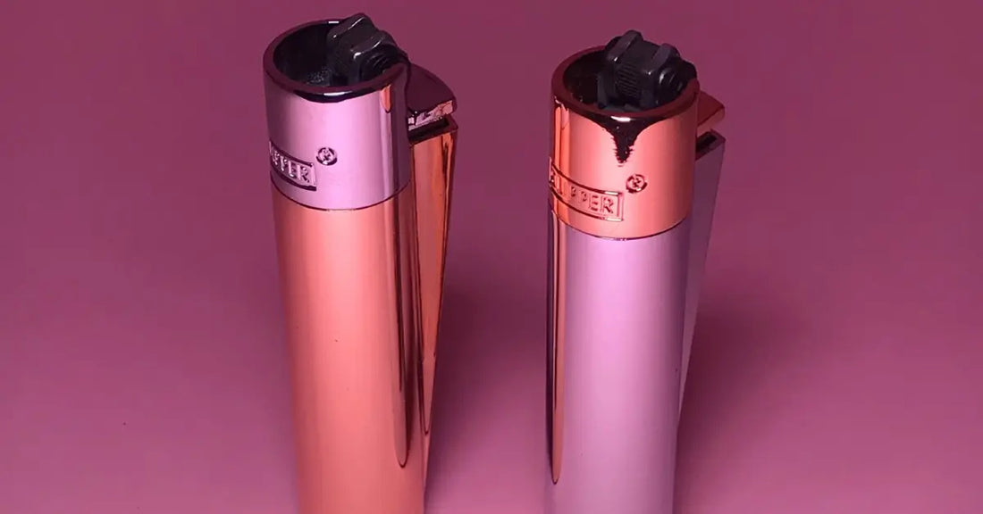 Two metallic Clipper lighters in rose gold and pink displayed on a pink background